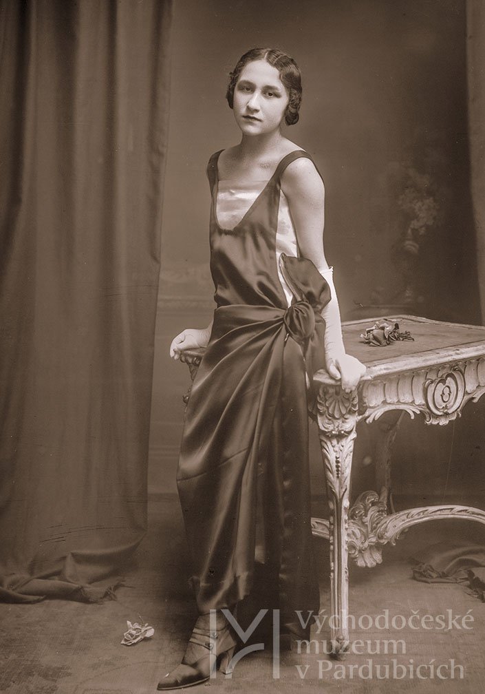 Ateliérová fotografie – mladá žena opírající se o stolek, 20. léta 20. století